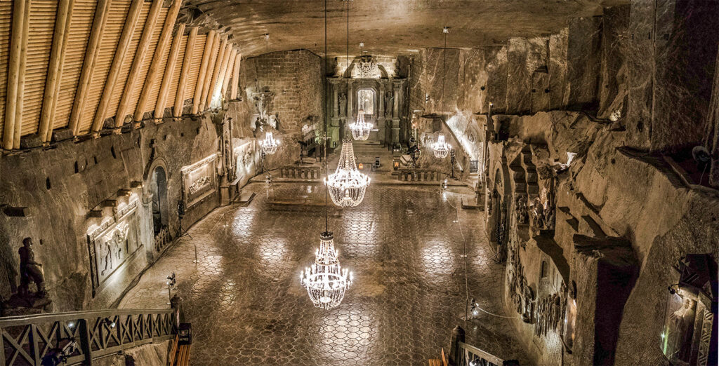 Interior da capela da mina de sal de Wieliczka com candelabros e esculturas de sal intrincadas.